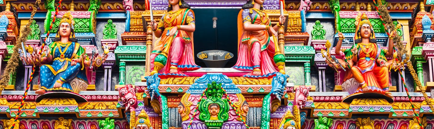 Pathirakali Amman Hindu temple exterior close up, bright vibrant carvings, statues of women, lions, colourful decoration