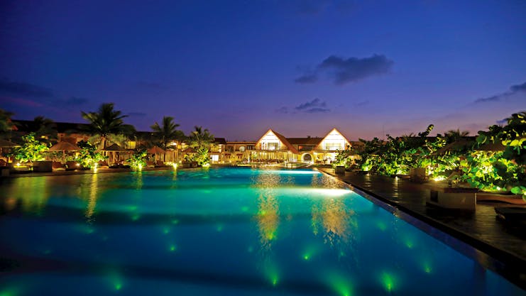 View of the pool and resort lit up at night 