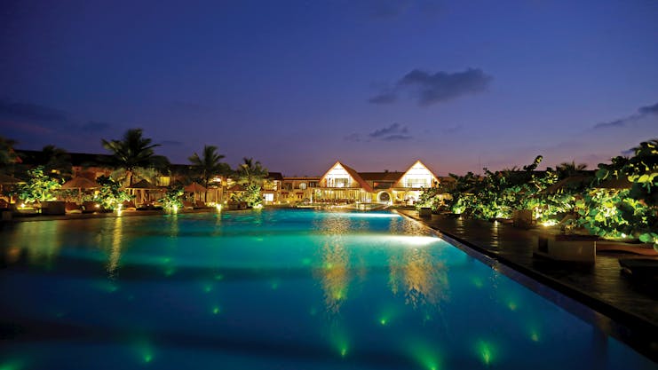 View of the pool and resort lit up at night 