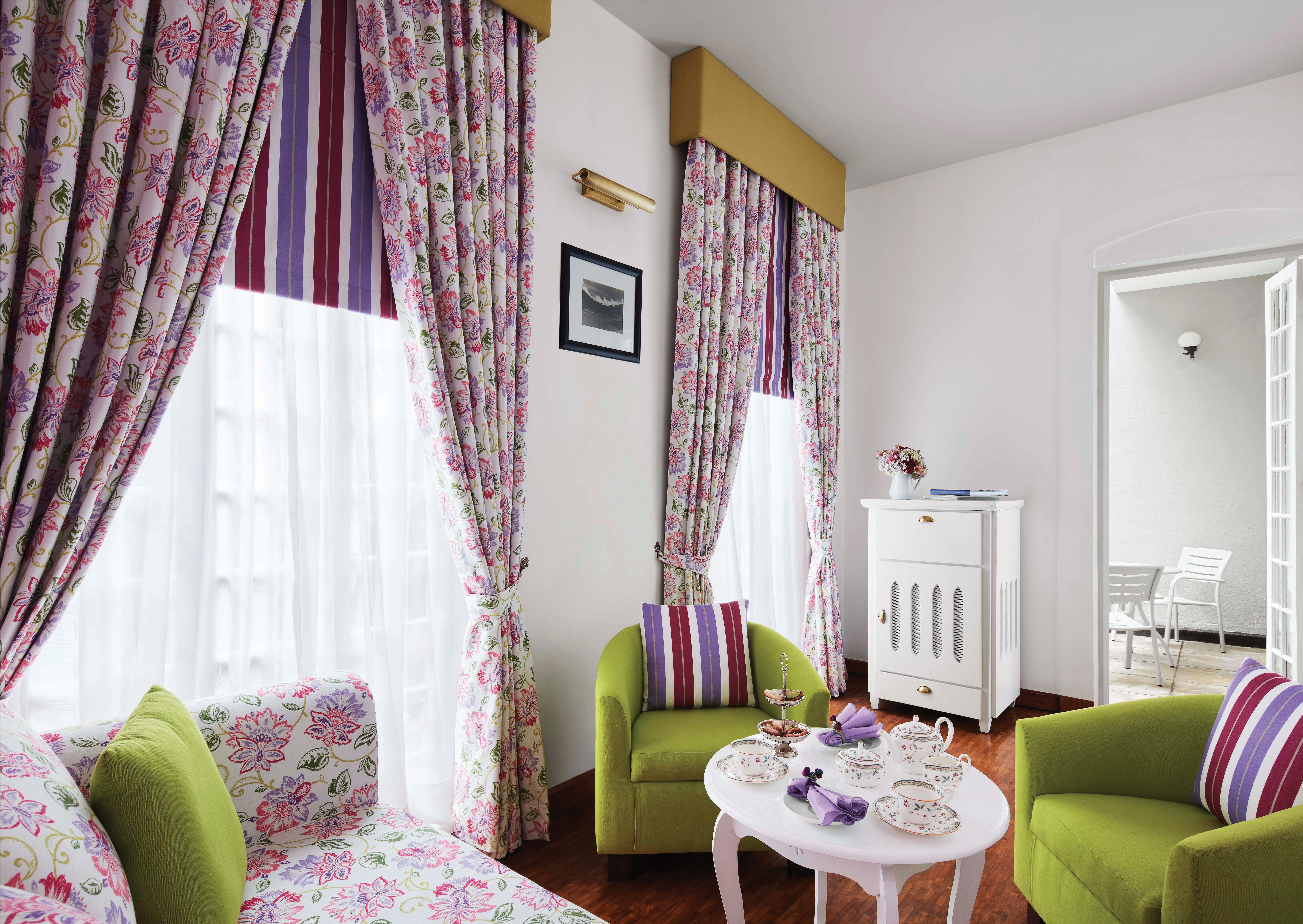 Magnolia cafe with pink and green colour scheme, draping curtains and arm chairs