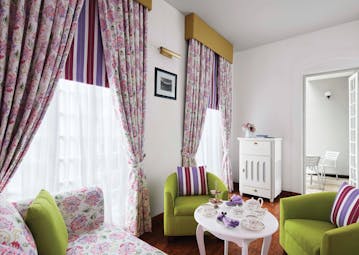 Magnolia cafe with pink and green colour scheme, draping curtains and arm chairs