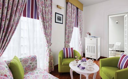 Magnolia cafe with pink and green colour scheme, draping curtains and arm chairs