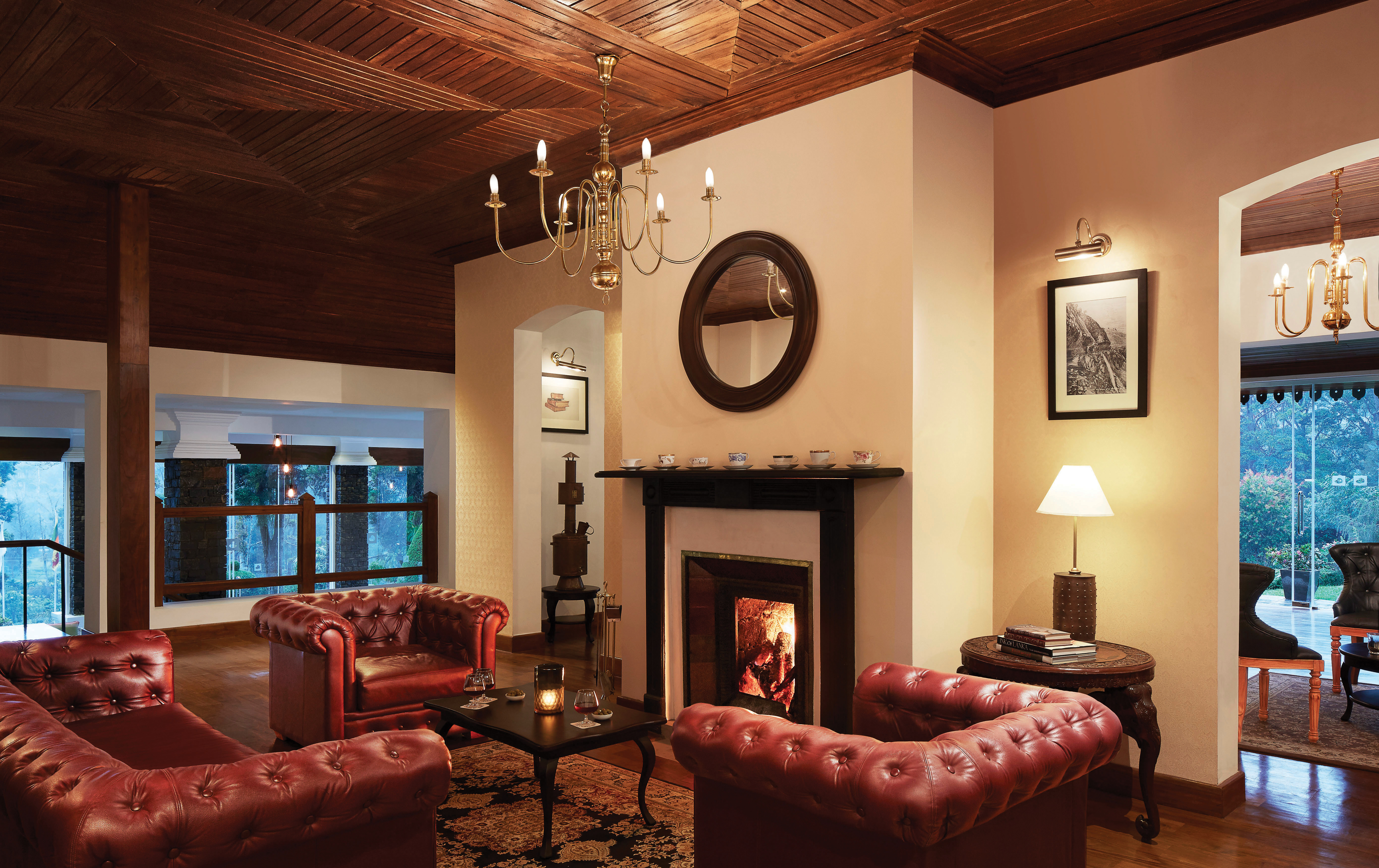 Lobby area with arm chairs, fireplace, chandelier and lampshades