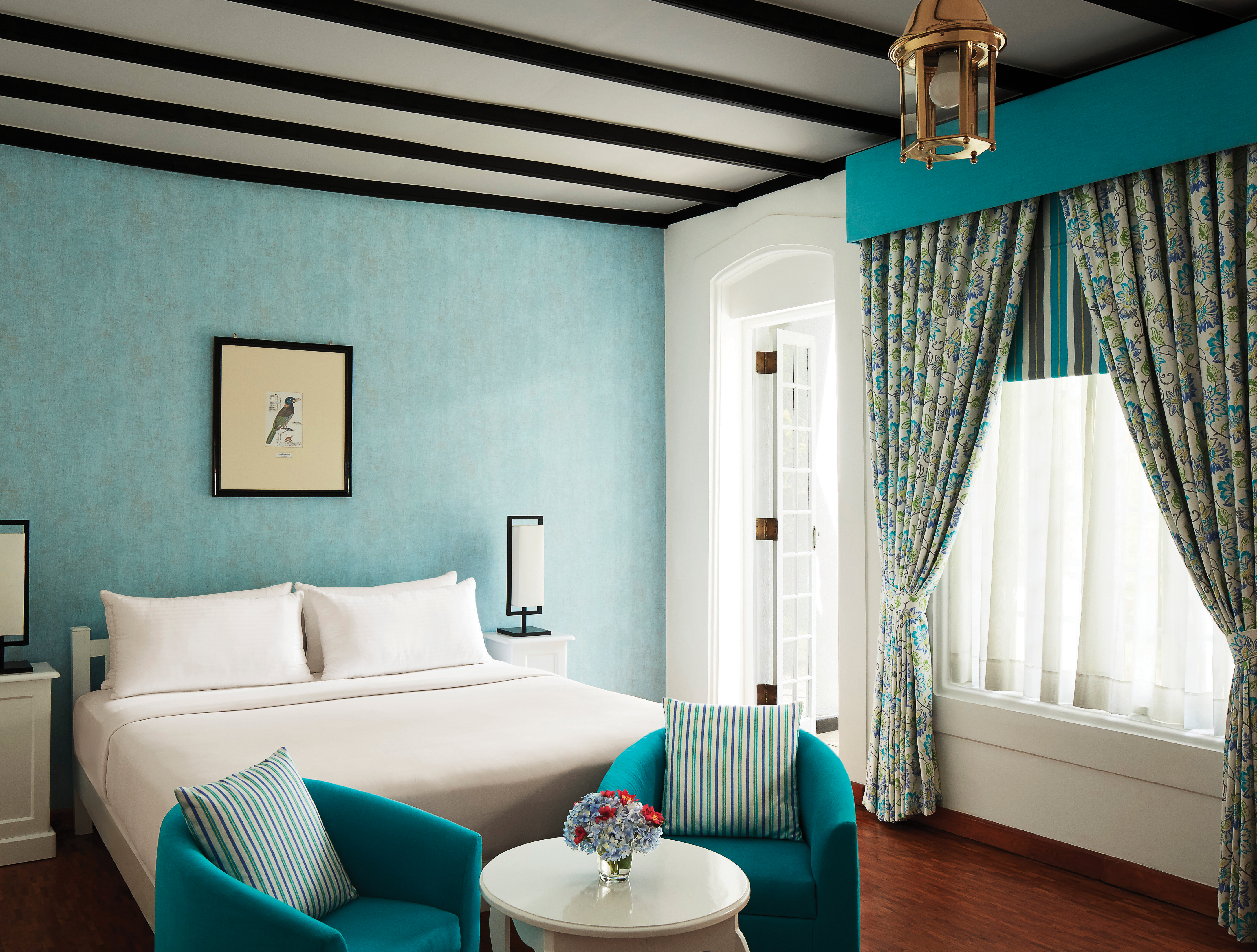 Superior bedroom with blue colour scheme, large double bed and draping blue curtains