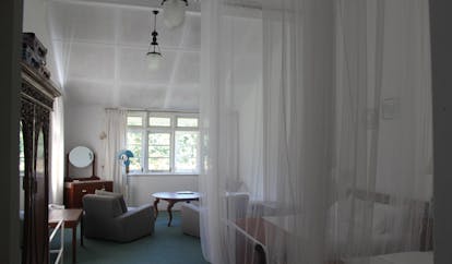 Kirchhayn Bungalow Sri Lanka bedroom mosquito drapes white decor armchairs