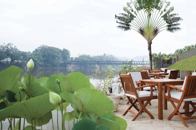 Mahaweli Reach Hotel riverside terrace, tables and chairs overlooking river