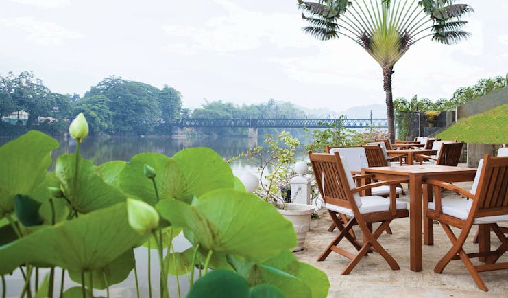 Mahaweli Reach Hotel riverside terrace, tables and chairs overlooking river