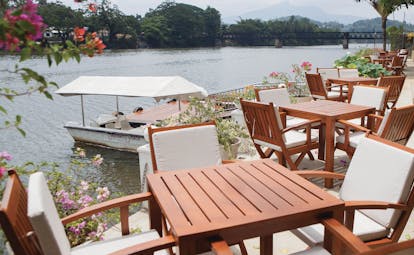 Mahaweli Reach Hotel terrace, tables and chairs overlooking river