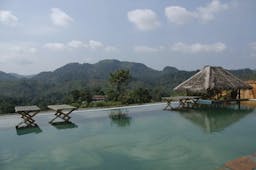 Rainforest Edge infinity pool overlooking mountains, cabana and chairs in the water