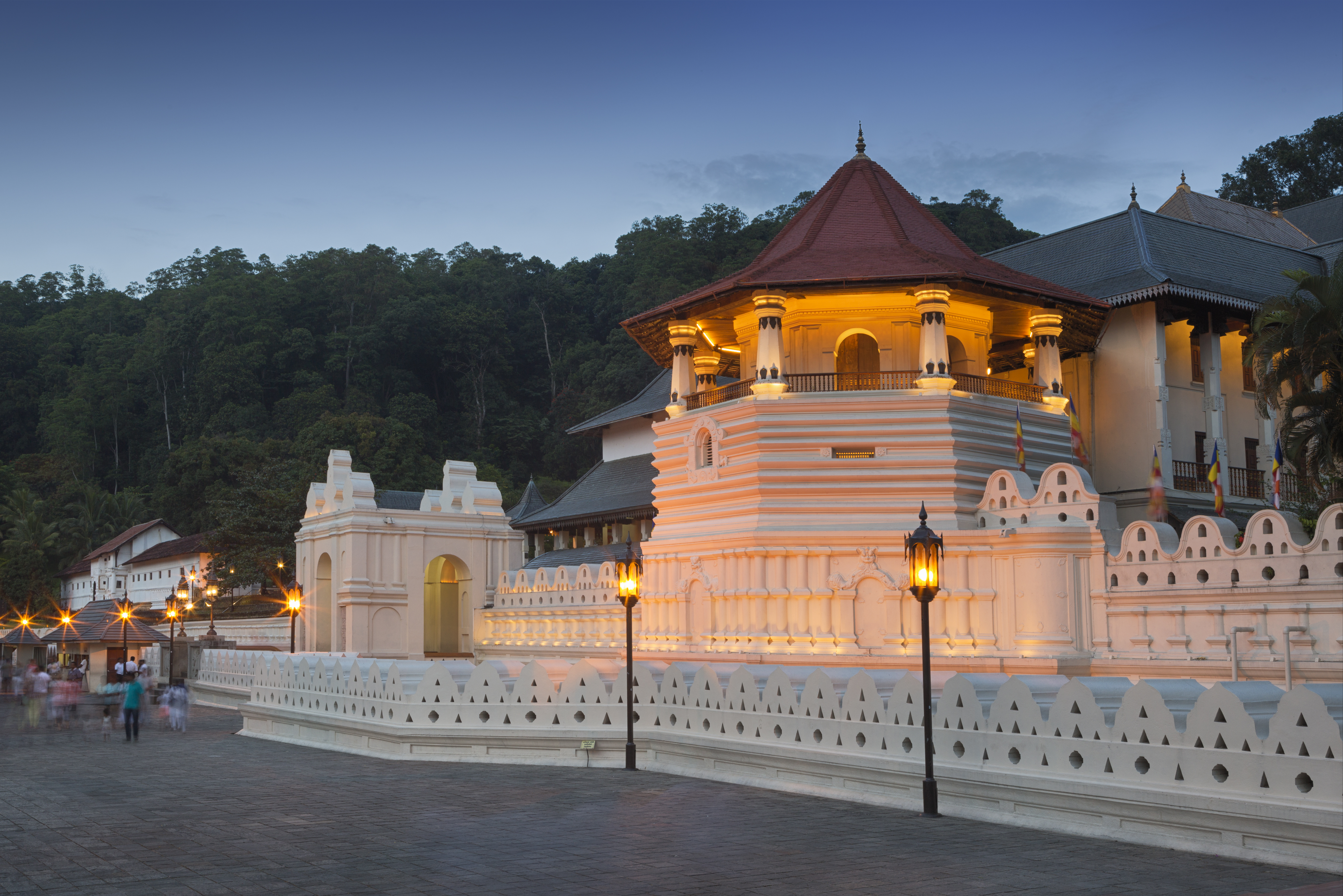 Exterior evening shot of the Temple of the Sacred Tooth Relic, white buildings lit up by lanterns