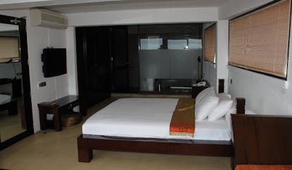 Theva Expressions Sri Lanka deluxe bedroom minimalist decor and glass wall to bathroom