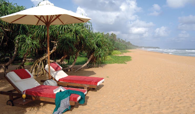 Aditya Resort beach with loungers and cocktails