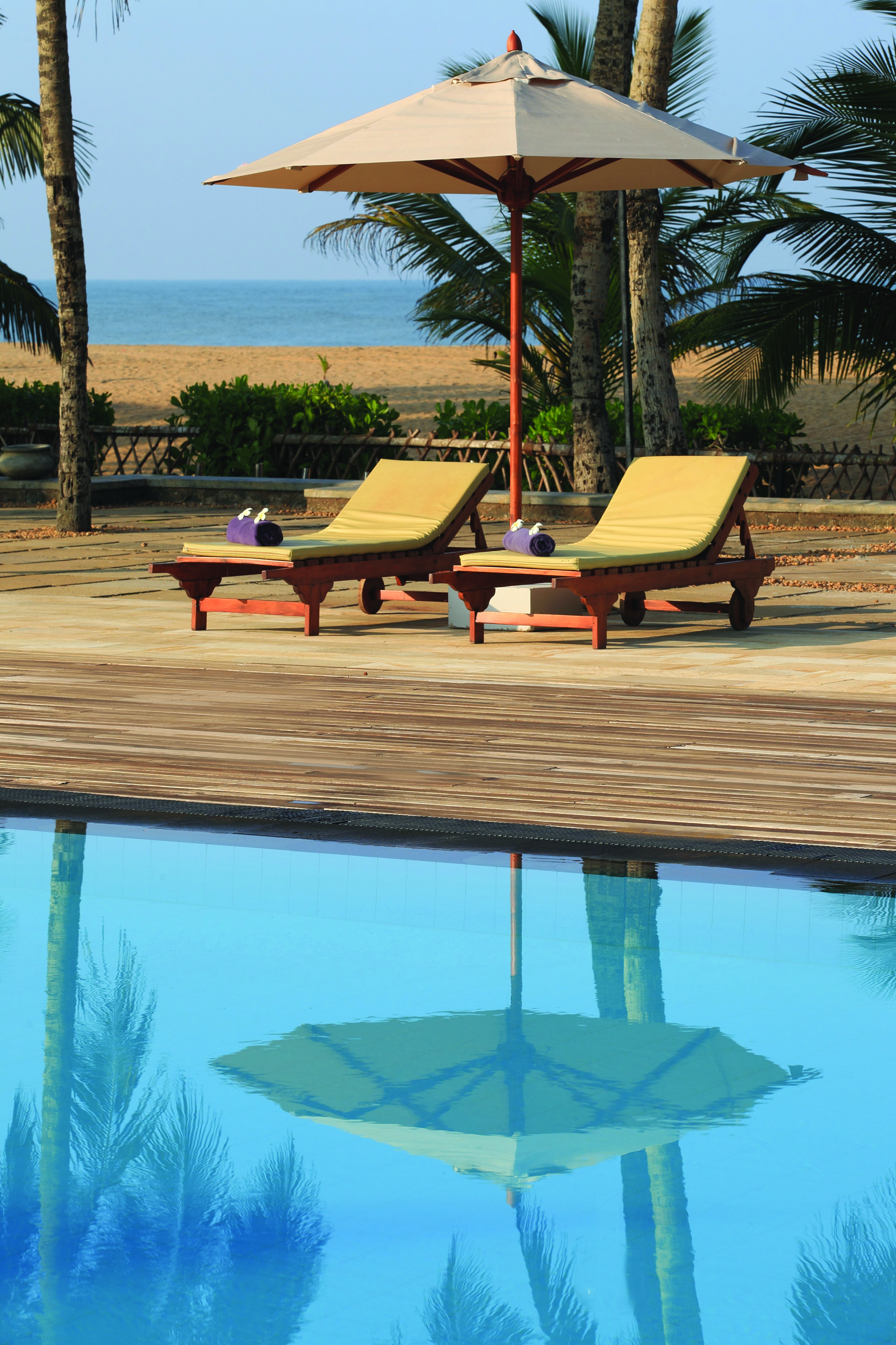 Avani Kalutara Sri Lanka poolside sun loungers umbrellas beach in background