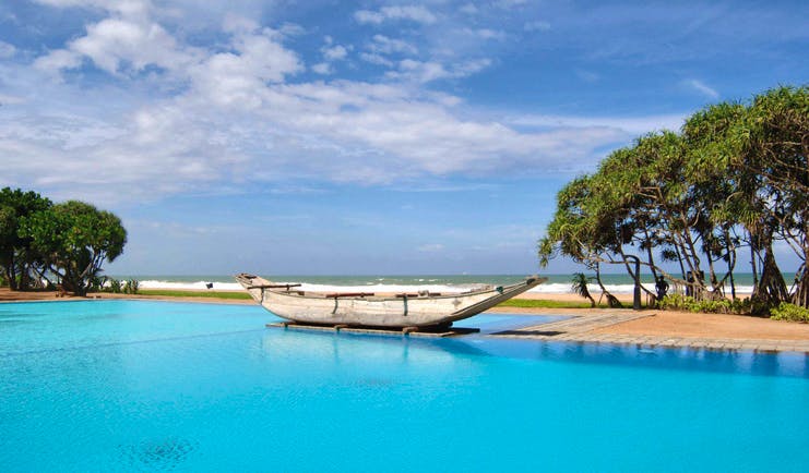 Outdoor pool with old traditional boat floating on it 