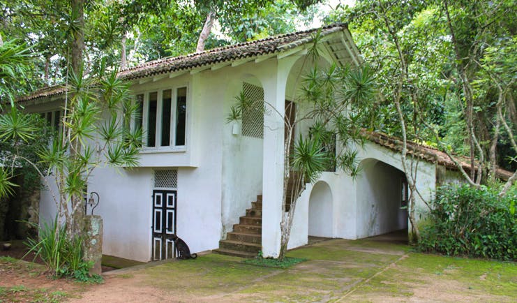 Lunuganga Sri Lanka gate house exterior white building with archways and trees