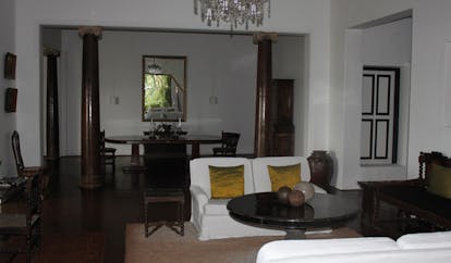 Lunuganga Sri Lanka main house lounge with chandelier columns sofa and dining table