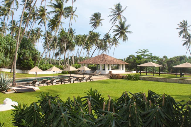 View of the gardens from the hotel with sunloungers and pool in distance