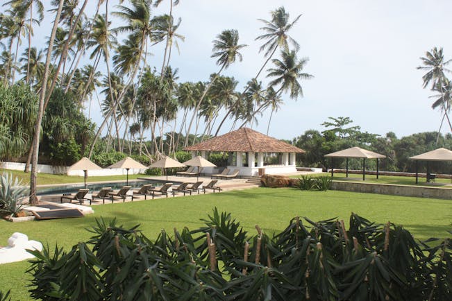 View of the gardens from the hotel with sunloungers and pool in distance