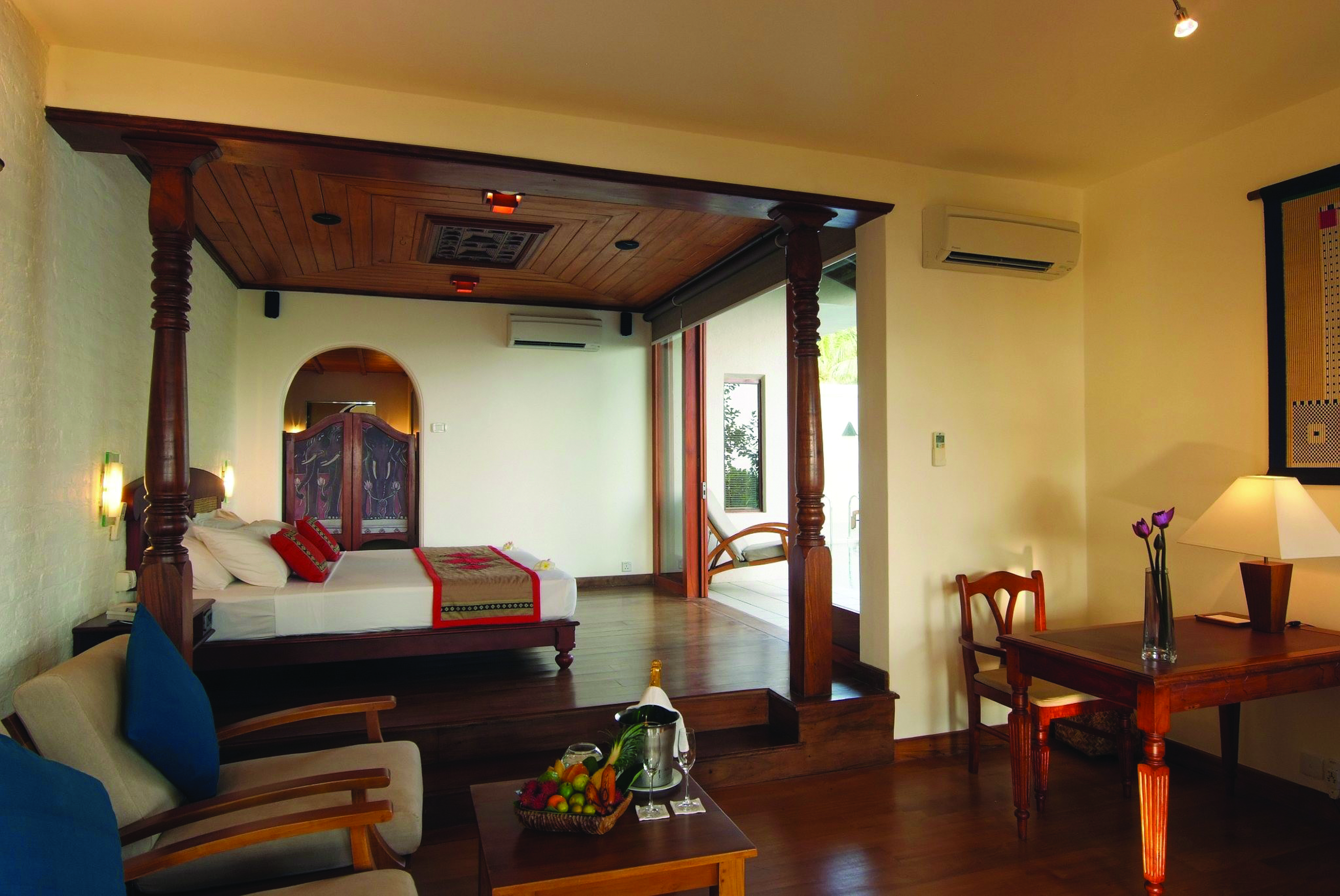 Saman Villas Sri Lanka grand deluxe suite bed lounge area elegant traditional décor