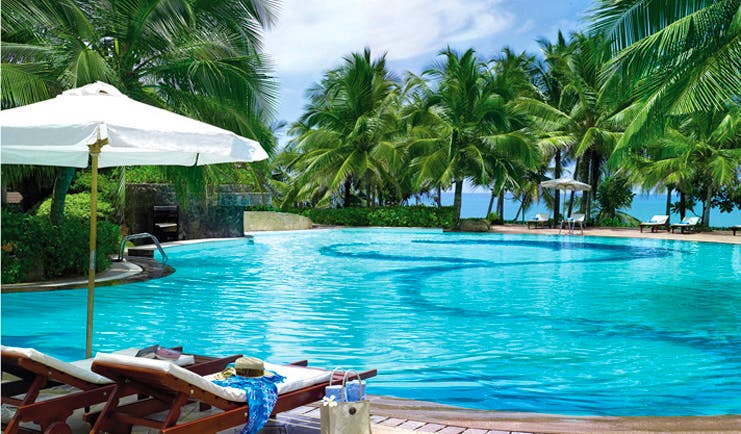 Taj Bentota Sri Lanka outdoor pool palm trees ocean view sun loungers