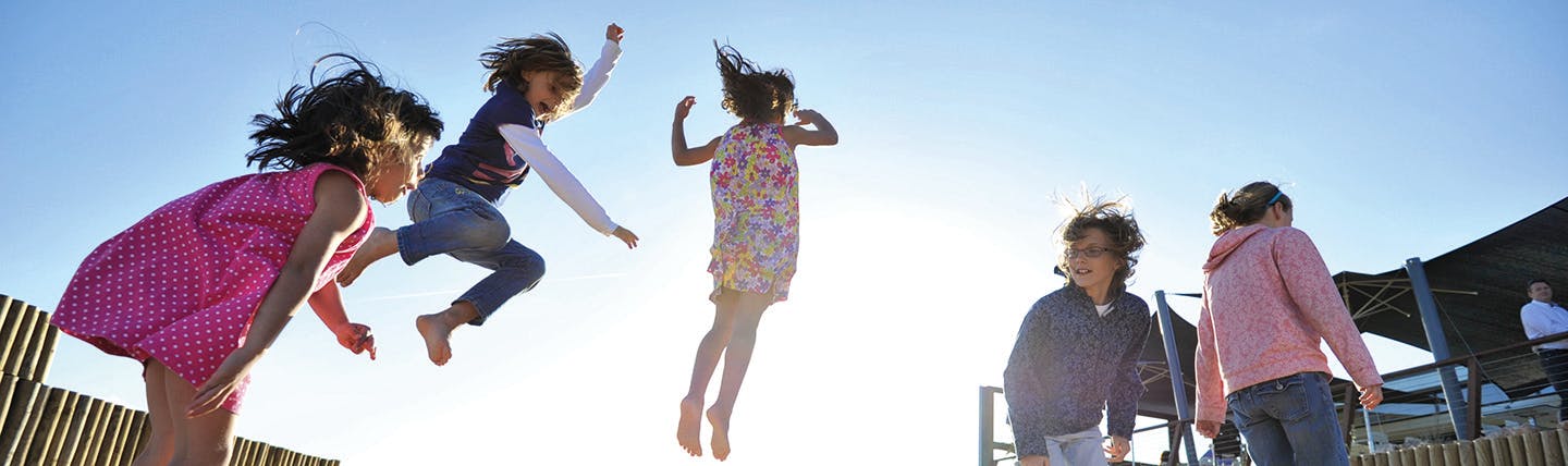 Children on a trampoline jumping with different dresses and clothes