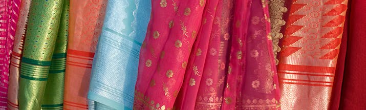 Silk material in shades of red and pink hanging up in Sri Lanka