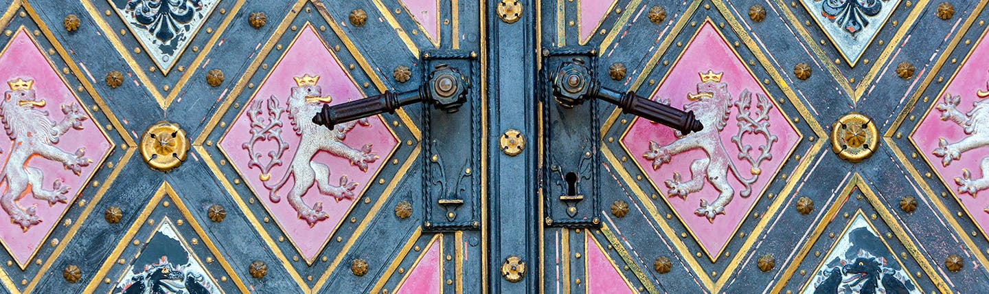 Ornate pink and grey doors of two-tailed lion and eagle at Vysehrad Prague