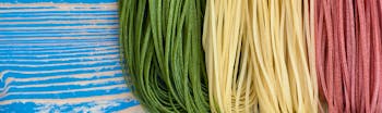 Green, white and red thin pasta strands resembling Italian flag