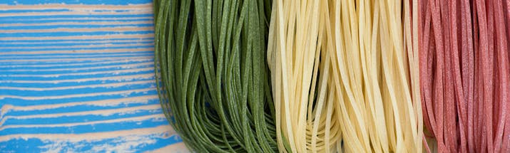 Green, white and red thin pasta strands resembling Italian flag