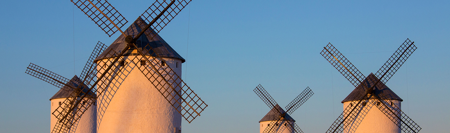 Four white windmills in the sun in La Mancha