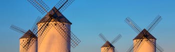 Four white windmills in the sun in La Mancha